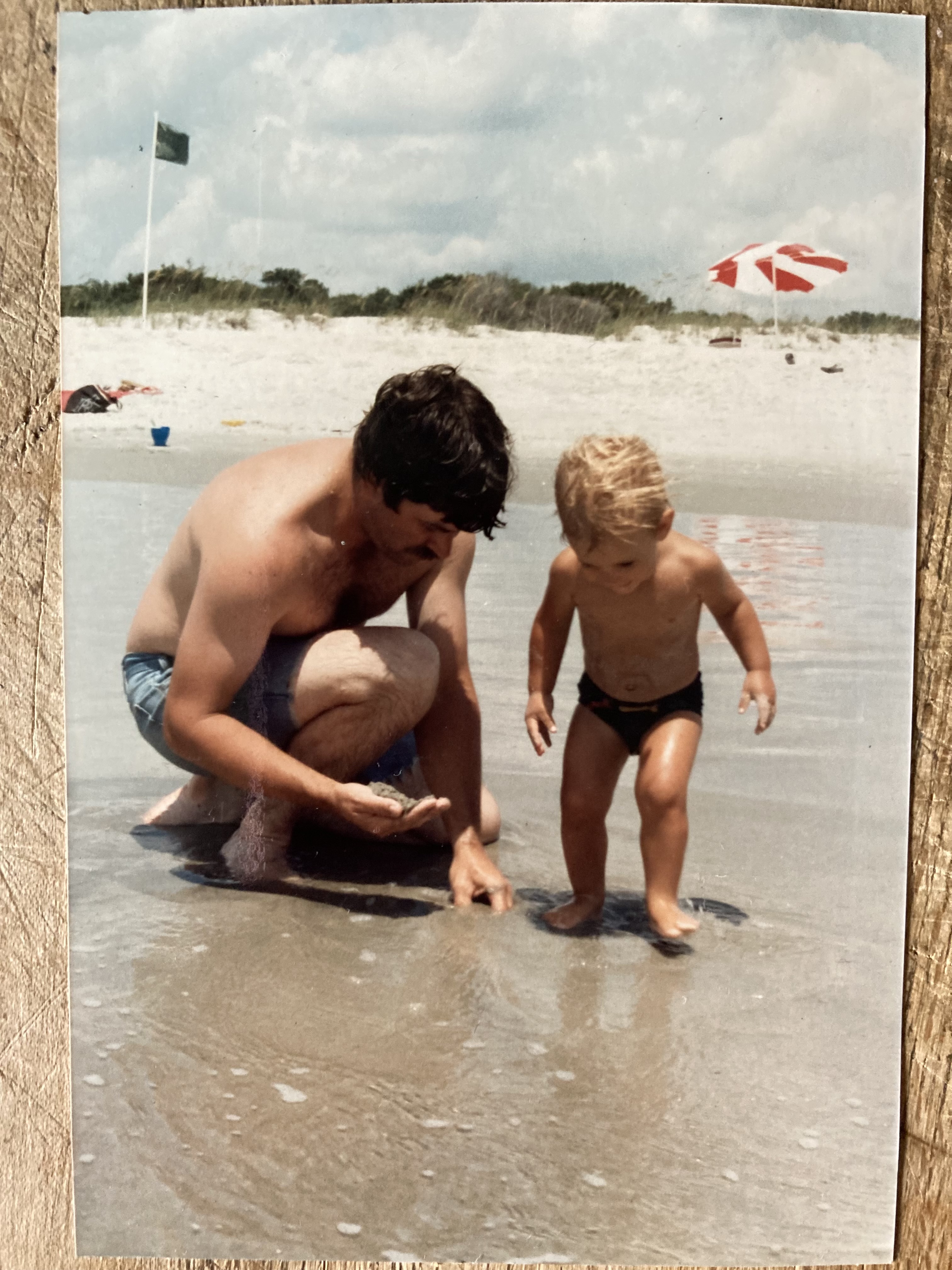 Gil Adams with a young child at the beach